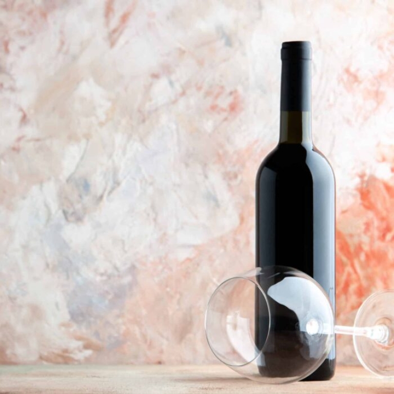 front view bottle wine with wineglass light background alcohol drink bar juice lemonade holiday dinner photo grape scaled e1723372136841 -